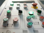 Control panel with various buttons and lights on a machine