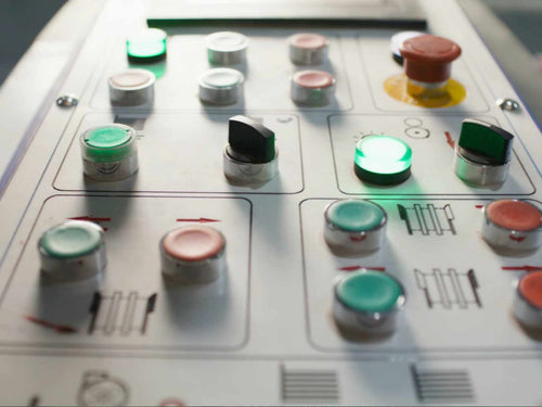 Control panel with various buttons and lights on a machine