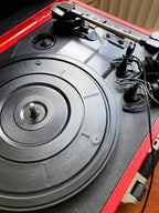 Close-up of a red and black turntable with a record on it.
