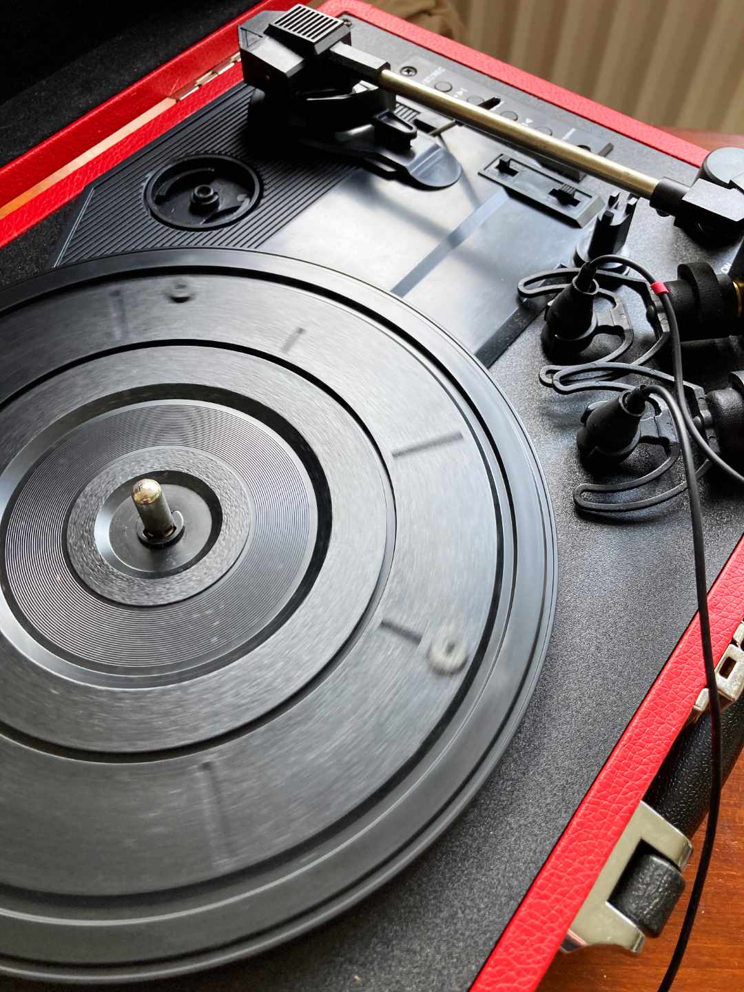 Close-up of a red and black turntable with a record on it.