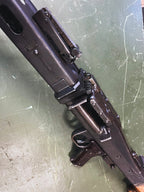 Close-up of a rifle on a scratched metal surface
