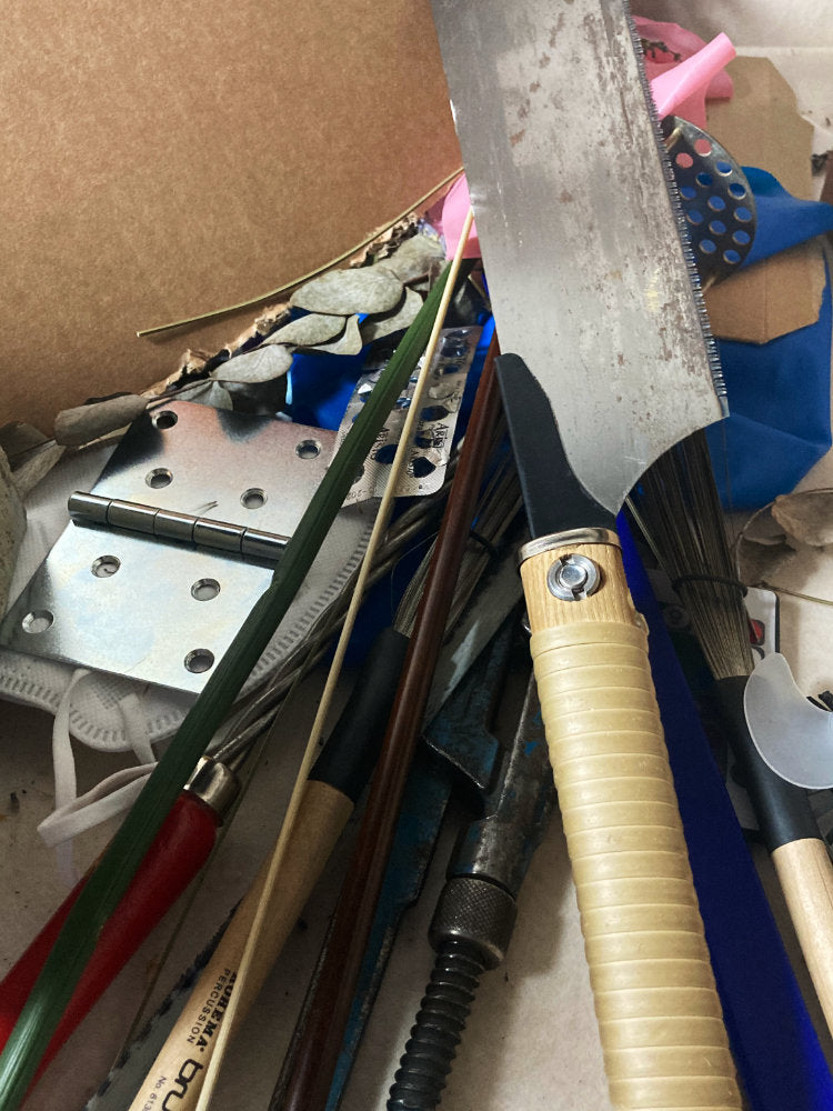 Collection of gardening tools including shears and pruners on a cluttered surface.