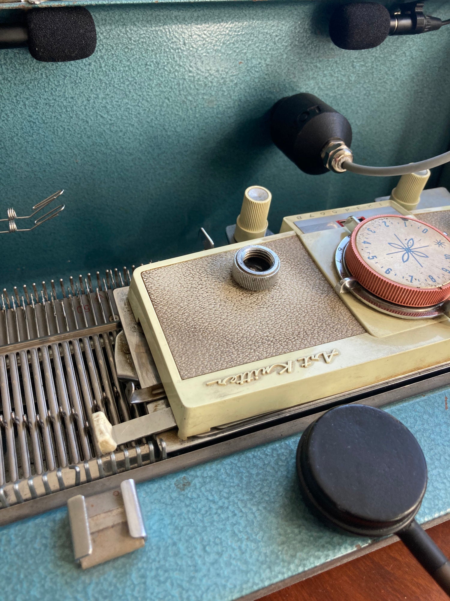 Close-up of a sewing machine with various components on a blue surface
